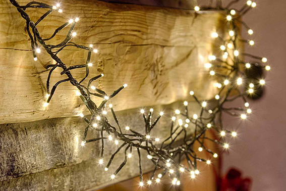 Decoración navideña con luces LED: guirnalda envuelta en una viga de madera para un toque rústico y elegante.